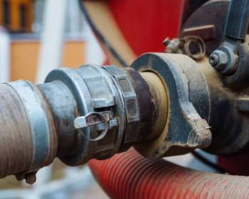flange fitting  connects a suction hose to a sewage tanker truck. Sewer pumping machine. Septic truck. Pumping wastewater from a septic tank. Septic tank maintenance