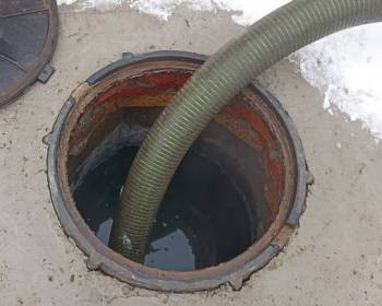 Pumping out a septic tank, a pipe in an overflowing cesspool close-up, cleaning the sewer system in a private home using a sewage truck